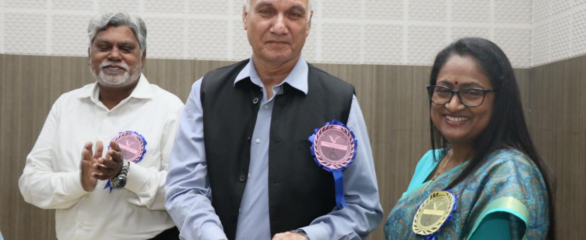 Prof. Ayub Khan presenting memento to Mrs. Radhika Rastogi. Prof. S. M. Rahmatullah also seen.